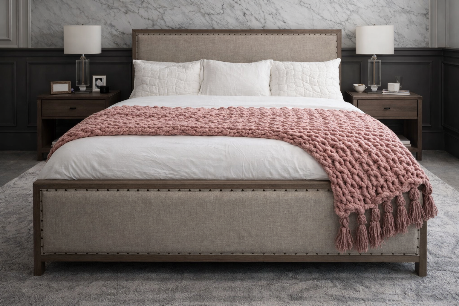 Pink Dust chunky chenille knit blanket 72x84 styled on neutral sofa styling. Beige upholstered bed with white bedding and a pink blanket in a bedroom setting.