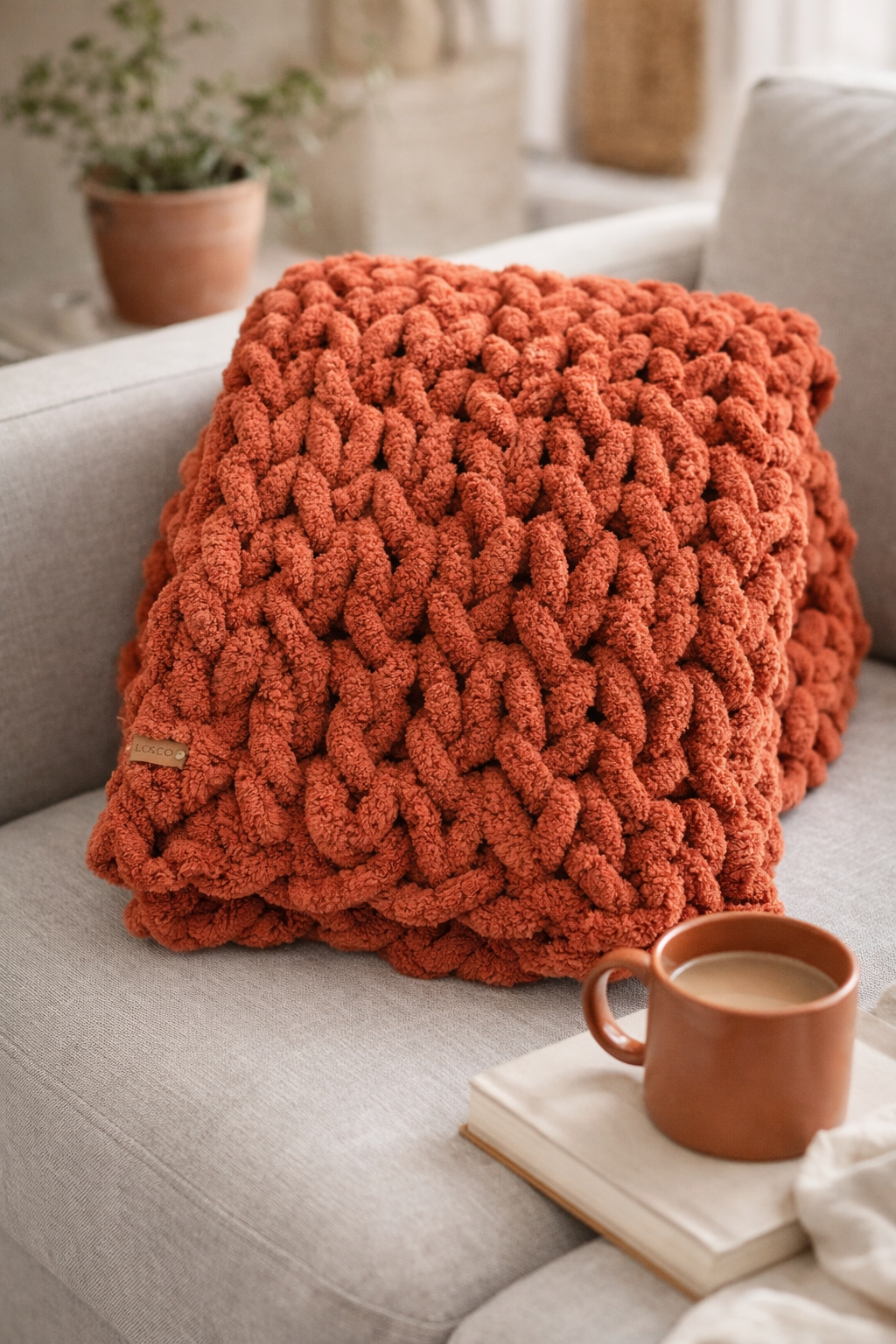 terra cotta chunky chenille knit blanket folded in quiet luxury living room