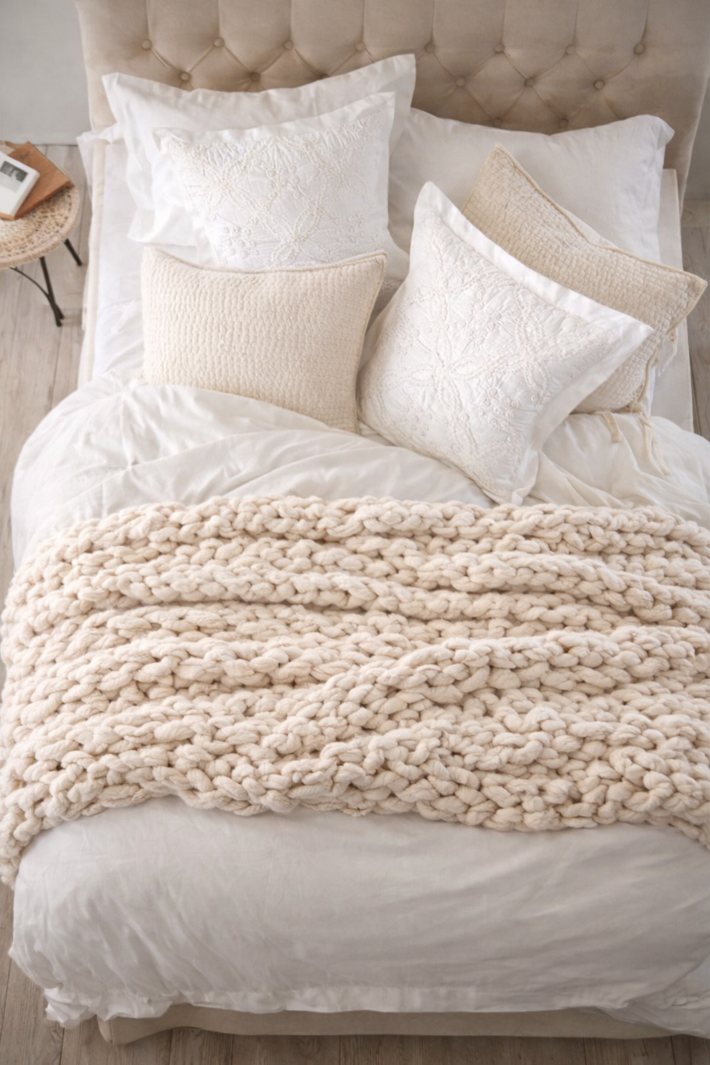 Neatly made bed with white bedding and beige textured blanket. Cream chunky chenille knit blanket 60x80 styled on neutral bed styling